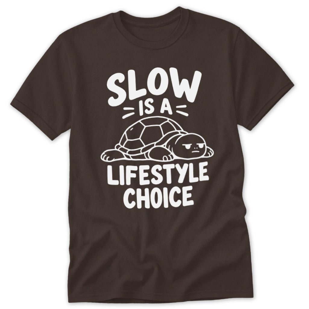 A dark brown t-shirt featuring white text that reads Slow Is A Lifestyle Choice surrounding an illustration of a resting turtle.